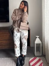 Pantalón de corte recto con estampado floral en tonos beige y negro.