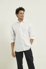 Camisa blanca de algodón premium, corte clásico, cuello inglés, cartera abotonada, mangas largas con puños ajustables y bajo redondeado.