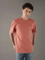 Remera color salmón de corte recto, cuello redondo y mangas cortas. Estampado pequeño del logo de Calvin Klein Jeans en el pecho.