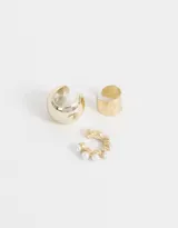 Set de tres earcuffs dorados: uno liso, uno con textura y uno con perlas de imitación.