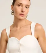 Blusa blanca de tejido plano en sastrería, con escote corazón, breteles anchos, botones forrados, elástico en la espalda y bajo con recorte V.