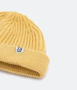 Gorro corto tipo beanie color beige, tejido en lana acrílica con textura acanalada.