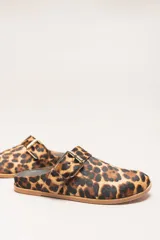 Sueco destalonado de cuero vacuno color negro, con hebilla ajustable dorada y detalles de tachas doradas.