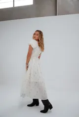 Vestido corto color crema con estampado floral, escote cuadrado con lazo ajustable, mangas cortas abullonadas y corte princesa.