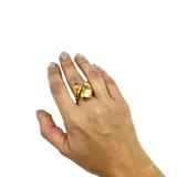 Anillo de acero dorado con aplique de nácar y cristal.