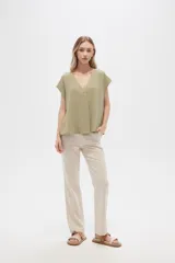 Pantalón de lino color verde oliva con estampado de flores color crema, de corte recto.