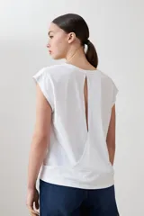 Remera blanca de corte recto, con escote en V y mangas cortas. Presenta detalle de abertura en la espalda.