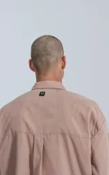 Camisa manga larga rosa con bolsillo con ojal y botón en delantero, de calce oversize confeccionada en textil plano fresco y liviano.