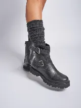 Bota corta negra de cuero con suela track y doble hebilla metálica.