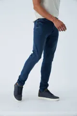 Jean skinny de tiro medio, color azul oscuro, con logo bordado y pasacinto.