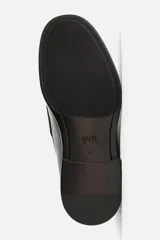 Mocasín de vestir color marrón oscuro, con detalle de borlas en la parte delantera, horma redonda y suela con ligero tacón.