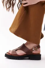 Sandalias marrones de cuero con suela track negra y hebilla plateada.