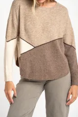 Sweater de tejido de punto con diseño de bloques de color en tonos beige, blanco roto y bordó. Presenta cuello redondo y mangas largas.