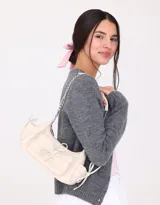Bandolera color crema de tela deportiva acolchada con diseño de rombos. Tiene manija de cadena metálica, cierre superior, bolsillo frontal con lazo y bolsillos laterales con lazo.