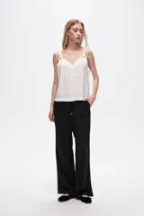 Pantalón negro de rayon, corte amplio, tiro alto y bolsillos laterales.