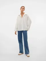 Camisa blanca oversize de manga larga con cuello clásico, puños abotonados y cierre frontal de botones.