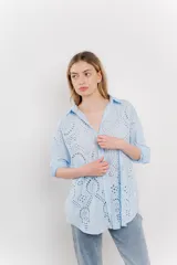 Camisa celeste de algodón con bordado calado tipo broderie, manga larga con puño angosto y botones al frente.