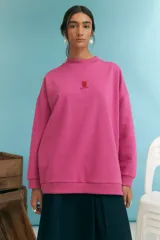 Buzo fucsia de corte holgado, cuello redondo y manga larga.