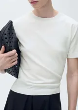 Jersey de punto fino color crudo, de manga corta y cuello redondo.