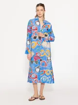 Túnica midi celeste con estampado de anteojos de sol de colores. Tiene cuello mao, cartera de botones oculta y mangas largas con puños acampanados.