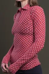Polo de manga larga color rosa con estampado geométrico en blanco, cuello polo clásico y cierre parcial con cremallera.