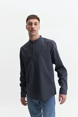 Camisa azul de manga larga con cuello mao y cartera abotonada.