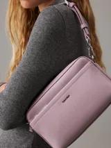 Bandolera Calvin Klein modelo Must, color lila, con correa ajustable y logo plateado en el frente. Incluye bolsillo exterior con cierre y bolsillo interior.
