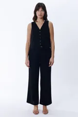Pantalón negro de lino, de corte palazzo y tiro alto.