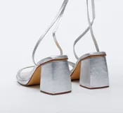 Sandalias plateadas con tiras finas y taco cuadrado.