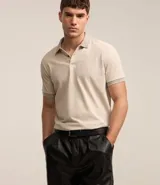Polo de manga corta color beige, confeccionada en algodón con cuello jacquard y ribete en las mangas.