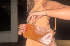 Cartera marrón de cuero con correa larga extraíble y bolsillo interior con cierre.