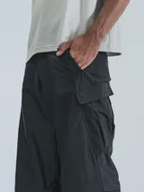 Pantalón negro tipo cargo con bolsillos laterales y corte holgado.