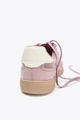 Zapatillas deportivas color rosa con detalles en blanco y suela color caramelo. Fabricadas con una combinación de materiales y cierre con doble cordón en contraste.