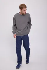 Buzo gris de manga larga y cuello redondo, con corte holgado y tejido de felpa suave.