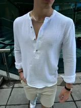 Camisa blanca de muselina con cuello mao y abotonadura parcial.