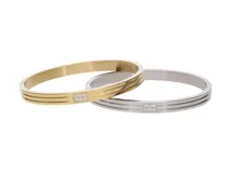 Pulsera rígida tipo brazalete de acero plateado con detalle central de circonias.