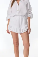 Short pollera blanco de tela arrugada con volados y detalles de encaje.