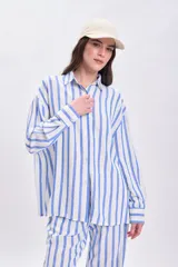 Camisa celeste y blanca a rayas verticales, de corte holgado y manga larga.