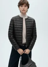 Campera puffer negra con cierre frontal y cuello redondo.