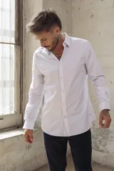 Camisa blanca de corte slim fit, manga larga y cuello clásico. Cierre frontal con botones.