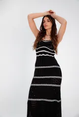 Vestido largo tejido a crochet, color negro con rayas horizontales blancas.