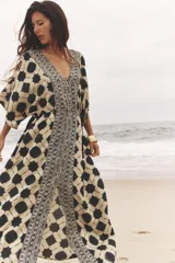 Vestido amplio estilo caftán con estampado geométrico en tonos beige y azul, escote en pico con lentejuelas y manga ancha por debajo del codo. Cintura ajustable con cordones con borlas.