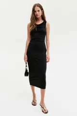 Vestido midi negro sin mangas en punto elástico con leve brillo. Modelo ajustado con frunces en escote, hombros y en un lateral de la cintura para crear un efecto drapeado.