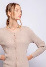 Cardigan negro elastizado de tejido de punto, corte al cuerpo, con cuello redondo y cierre frontal con botones a tono.