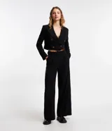 Pantalón de vestir negro de corte recto, con bolsillos laterales y traseros. Se ajusta a la cintura con cierre de botón y cremallera.