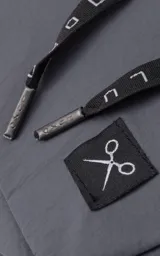 Bolso gris tipo drawstring con correa larga negra con logo de la marca en blanco.