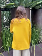 Sweater azul con diseño de flor en el frente y detalles de volados en puños y ruedo.