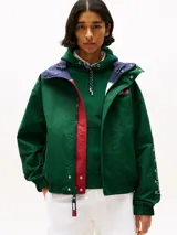 Campera náutica amplia reversible de nailon, con diseño color block en rojo, blanco y azul marino. Tiene capucha fija, cierre de cremallera oculto con botones a presión, puños y bajo elásticos, dos bolsillos ribeteados en la cintura, parche con logo de Tommy Hilfiger en el pecho y logo de Tommy Hilfiger en el cuello, las mangas y la espalda.