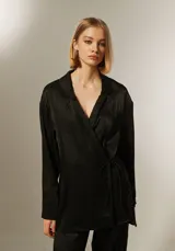Blusa negra con corte cruzado, escote en V, mangas largas y lazo lateral para ajustar.