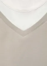 Remera color gris claro con cuello en V y mangas cortas. Diseño de doble capa con remera blanca debajo.